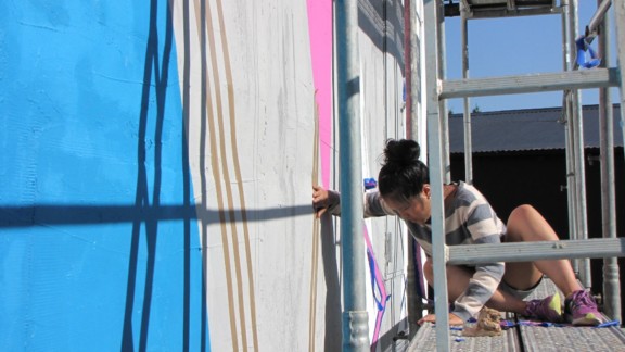 Kat Lam pracująca nad muralem "W jak Wieliczka"